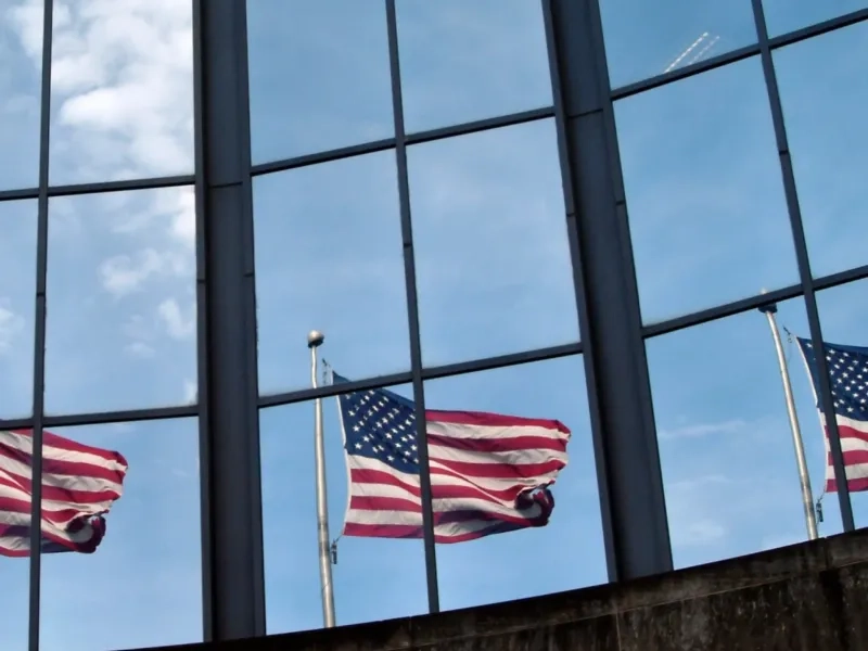 Three American flags outside windows