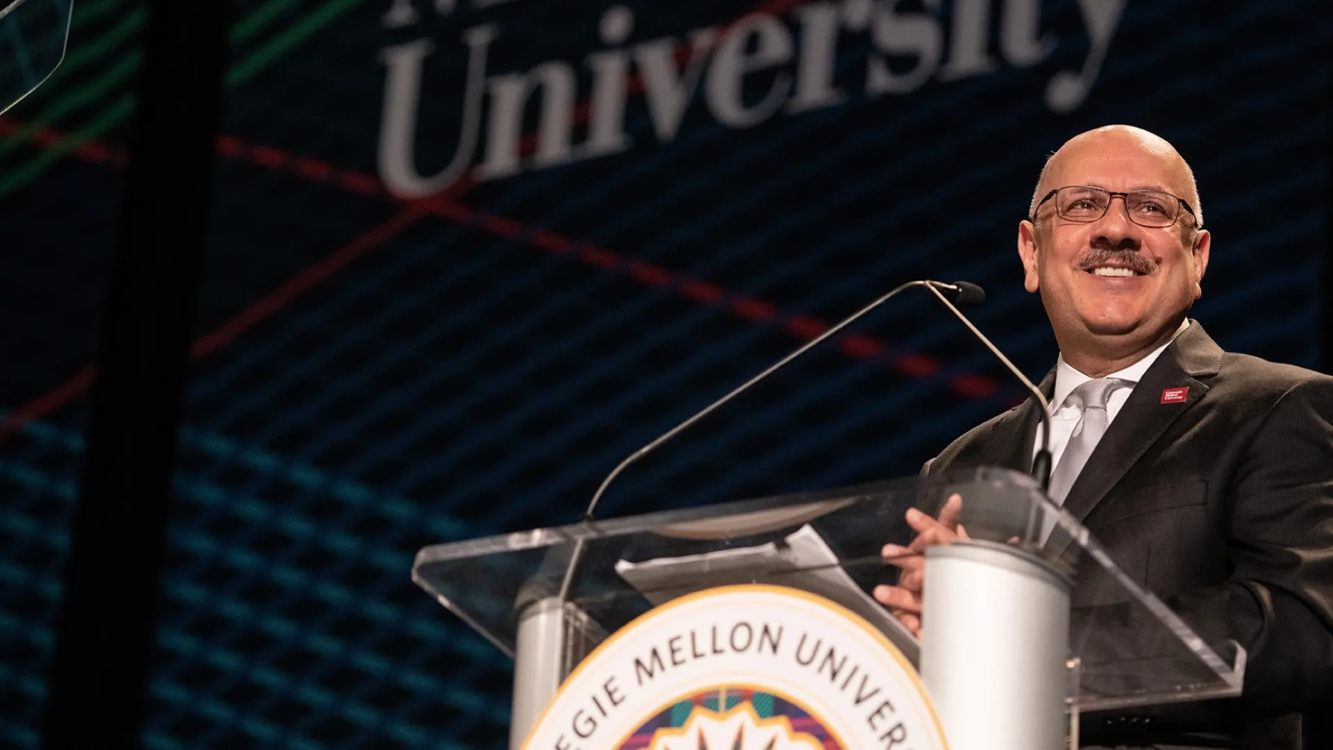 Farnam Jahanian smiling at a podium