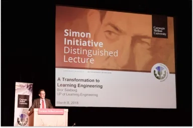 A man speaking at a podium for a Simon Initiative lecture