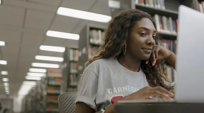 A student working on a laptop in the library.