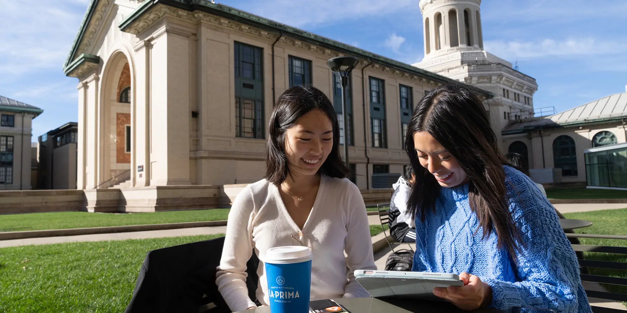 Two prospective students having coffee together on campus.